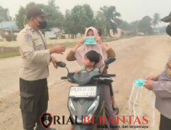 Asap Karhutla Menebal, Polsek Langgam Turun Bagikan Masker ke Warga
